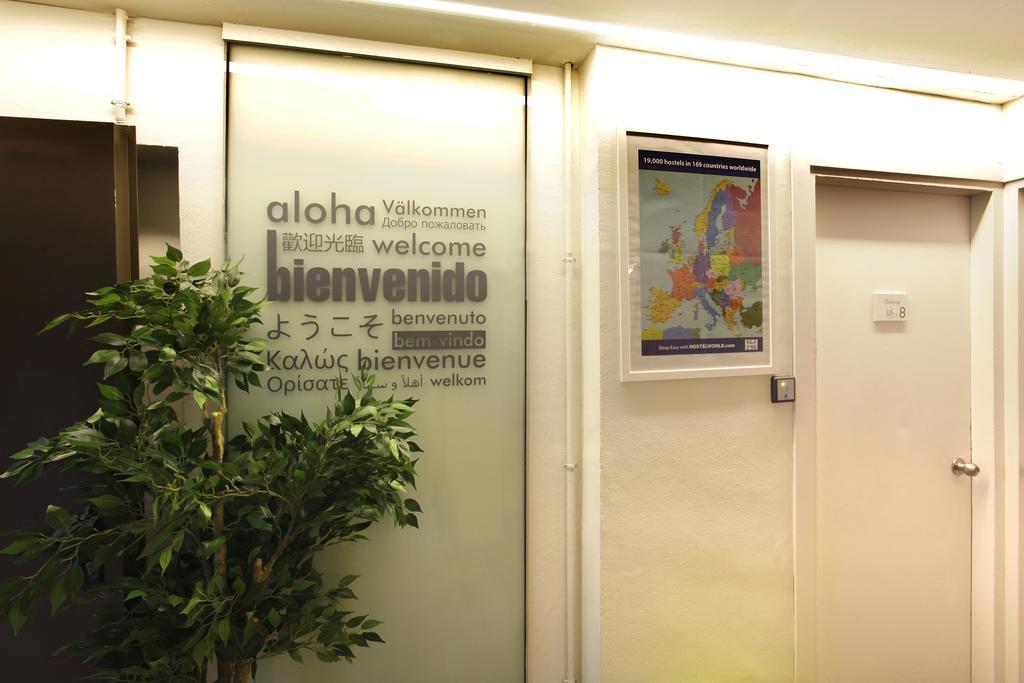 Gracia City Hostel Barcelona Bagian luar foto Aloha written in several languages at the entrance of a hotel in Geneva